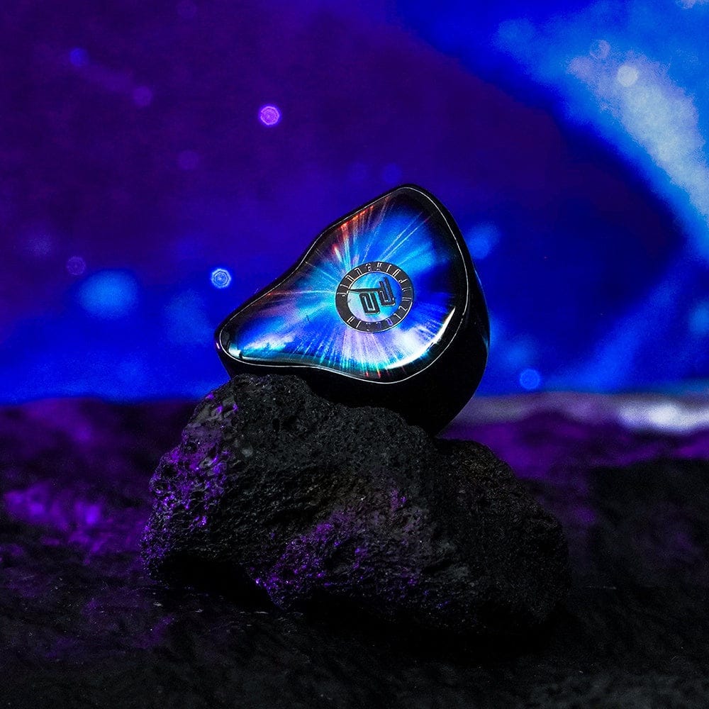 Single Nebula earpiece standing, faceplate lit blue-violet. Photo: Juzear Audio.